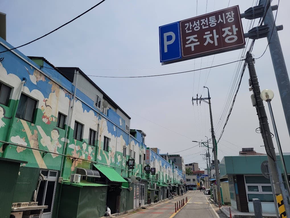 간성전통시장 주차장 표지판, 벽화 건물 늘어선 거리 풍경