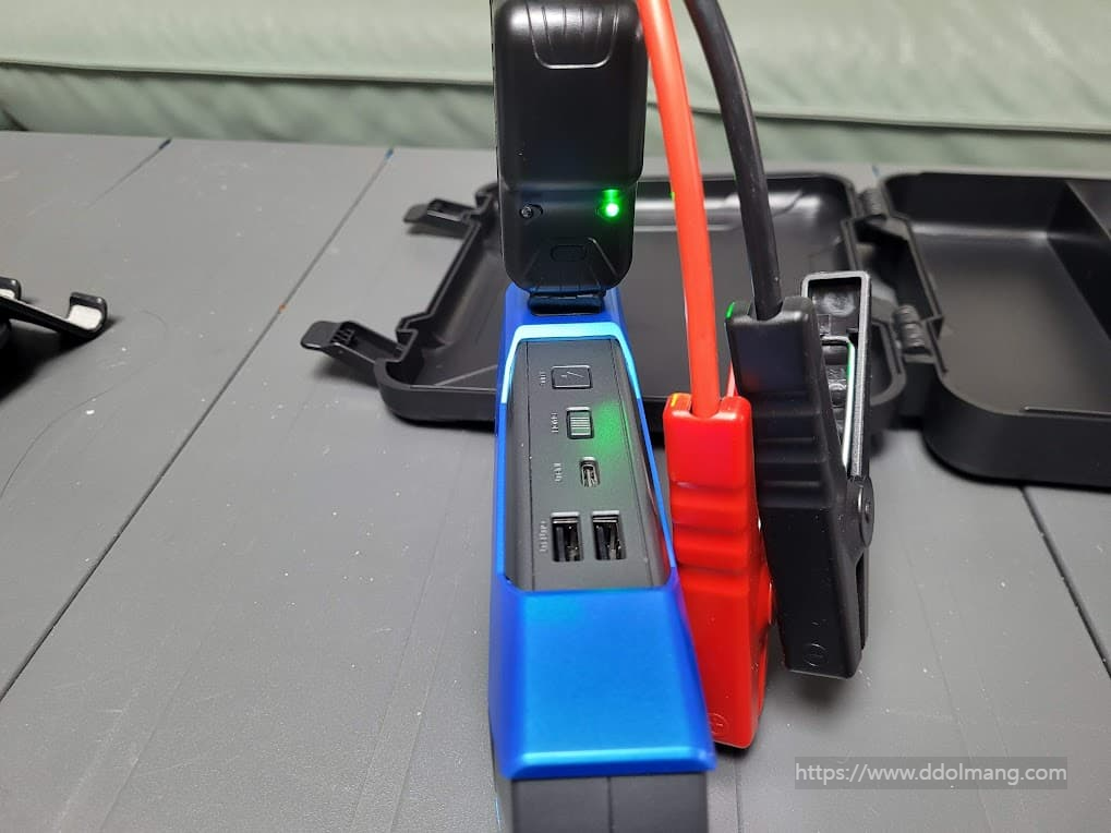 파란색 차량용 점프 스타터, 빨간색 검은색 점프 케이블, 녹색 표시등