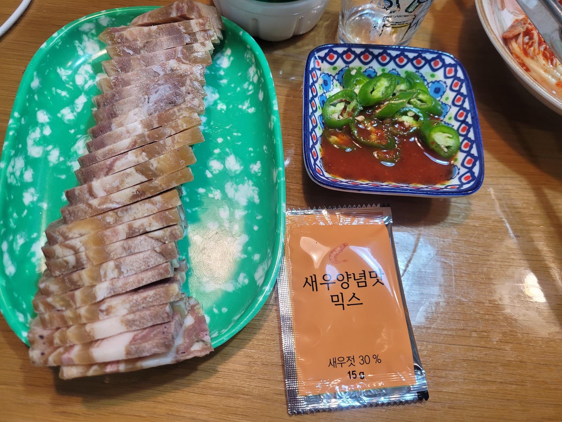 얇게 썬 편육 접시, 푸른 그릇 고추 양념, 새우 양념 믹스