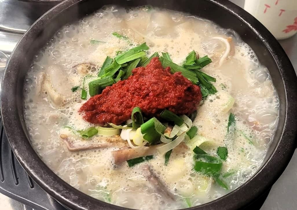 뜨거운 순대국, 뽀얀 국물, 빨간 다대기, 파, 부추, 뚝배기