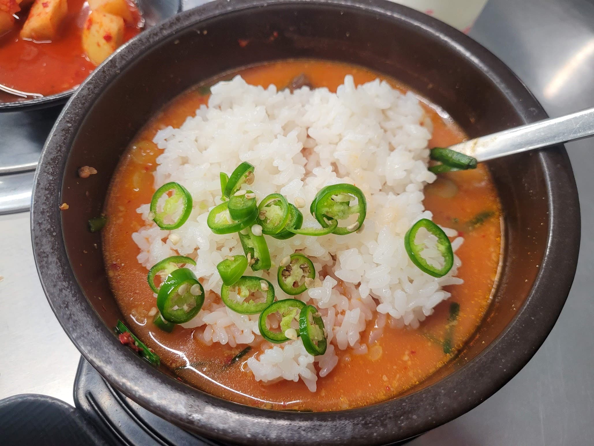 뚝배기 국밥, 하얀 쌀밥, 붉은 국물, 썰린 청고추