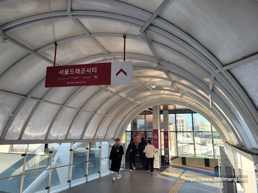 서울드래곤시티 안내 표지판, 아치형 통로 도심 배경.