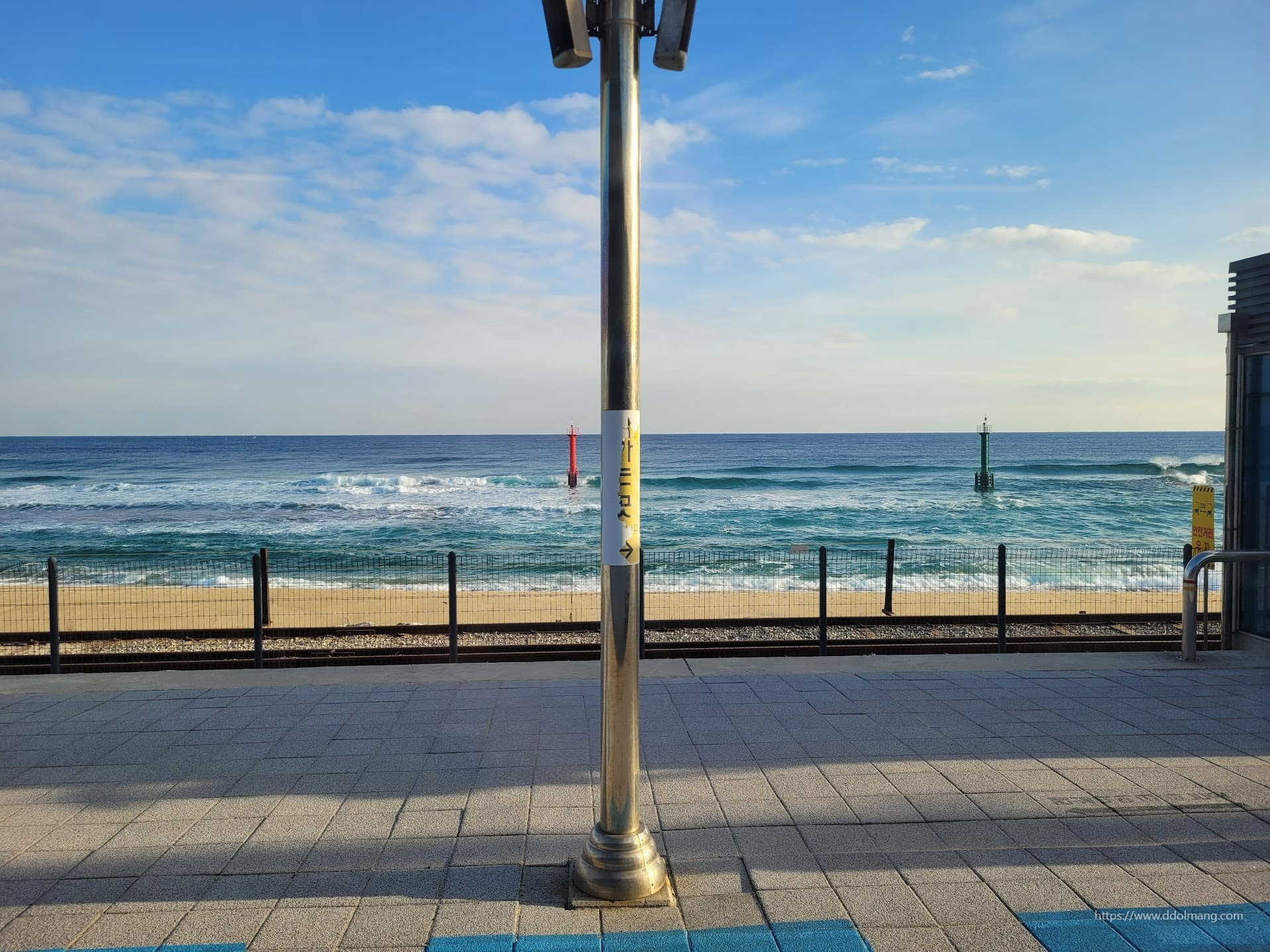 해변 기찻길, 파도치는 바다, 빨간색 녹색 부표, 중앙 기둥