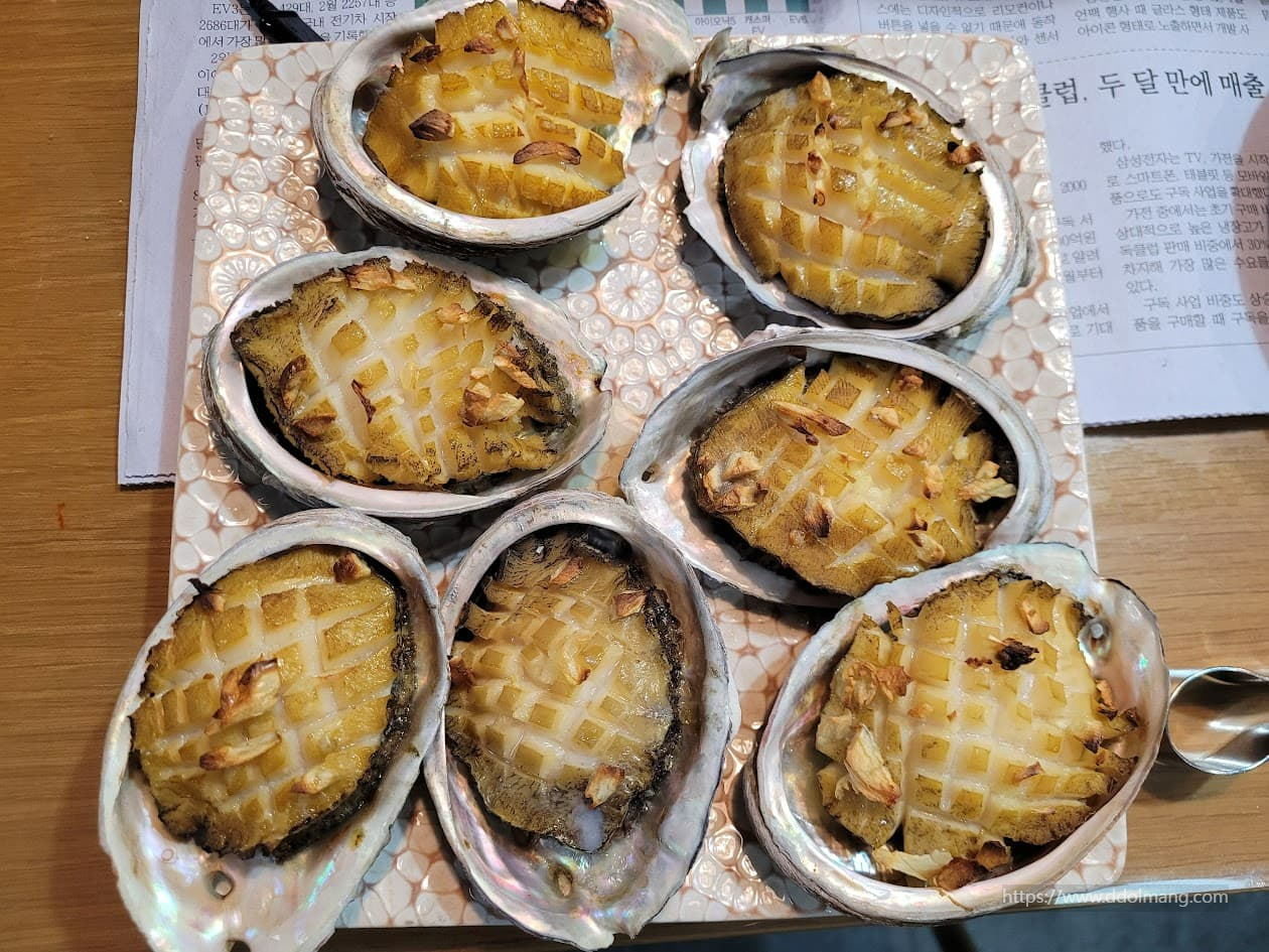 껍질에 담긴 황금빛 격자 무늬 전복 마늘구이.