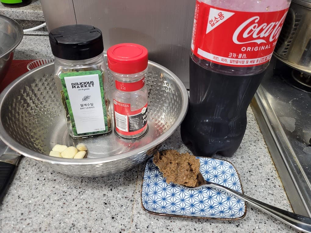 월계수잎, 마늘, 코카콜라, 양념 숟가락, 주방 조리대 위
