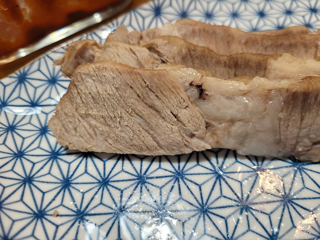 파란 무늬 접시 위 두툼하게 썬 보쌈 돼지고기