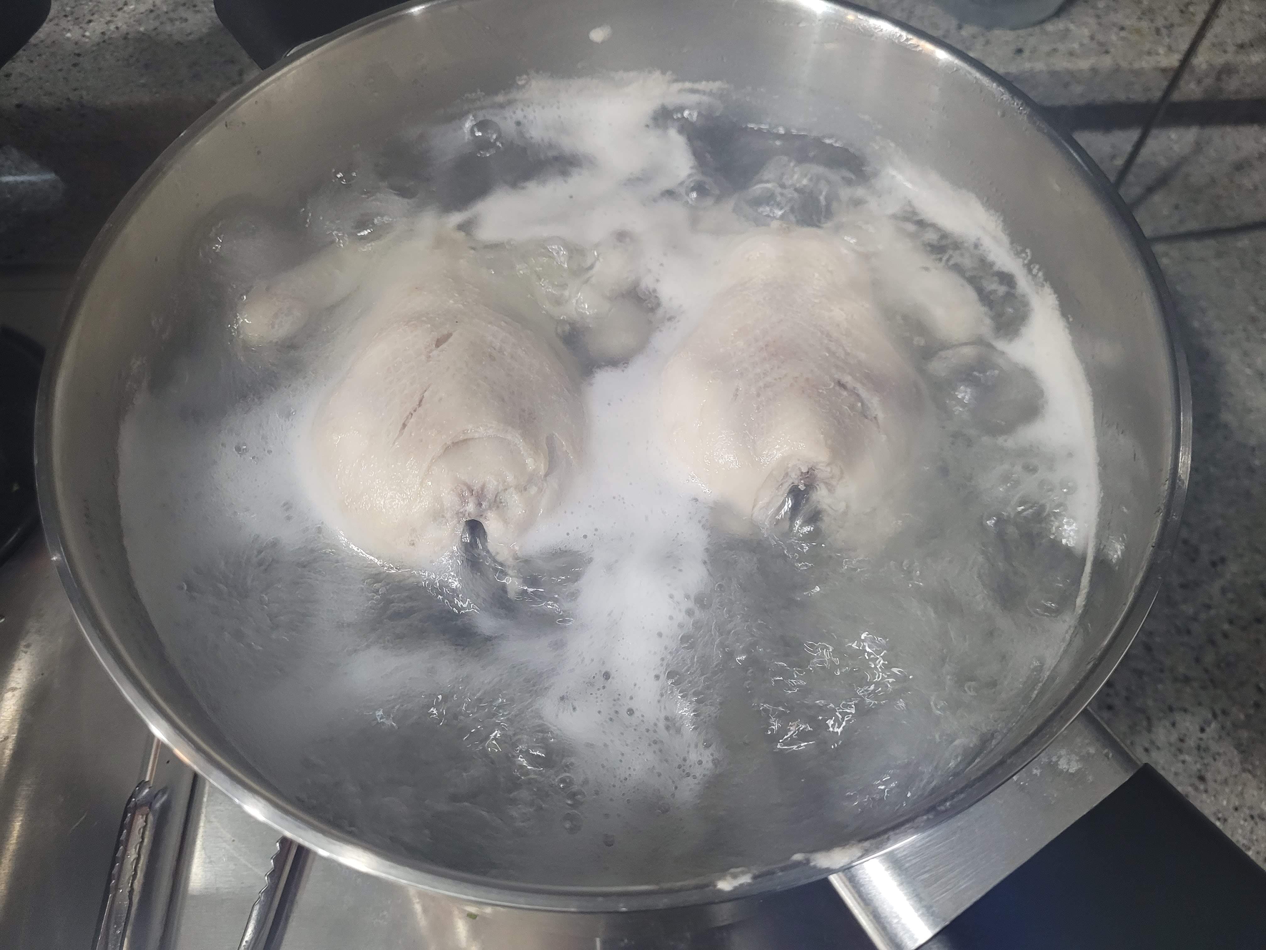 금속 냄비 거품 물에 통닭 두 마리 삶는 중