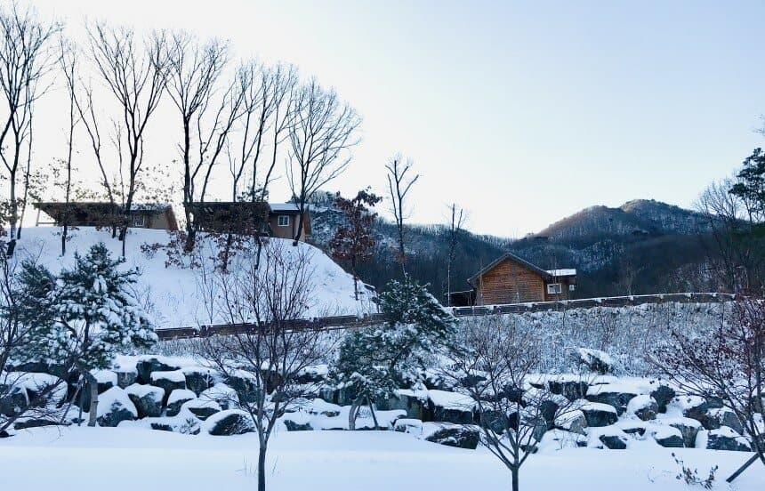눈 덮인 설원 오두막 여러 채, 겨울 산과 나무 바위