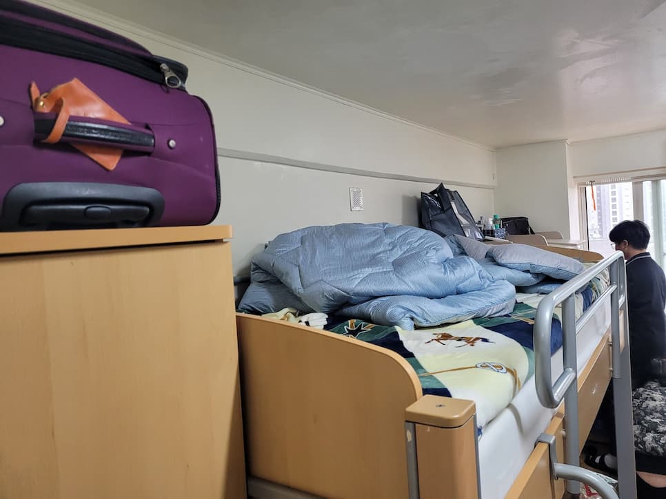 대학교 기숙사 방 이층 침대, 보라색 여행 가방, 도시 풍경