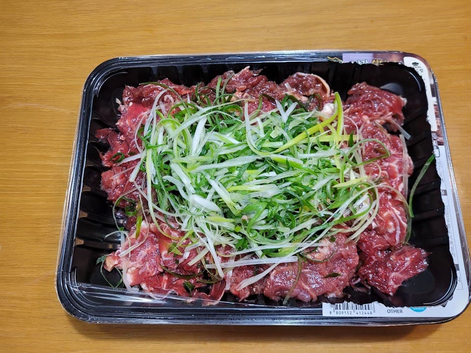 양념 소불고기, 신선한 파채 토핑, 검은색 플라스틱 용기