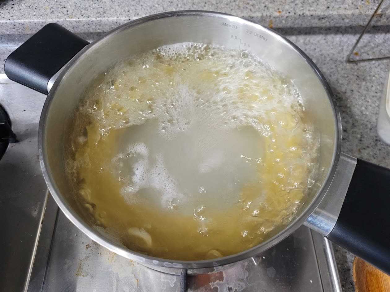 스토브 위 금속 냄비 속 끓는 마카로니 파스타 조리