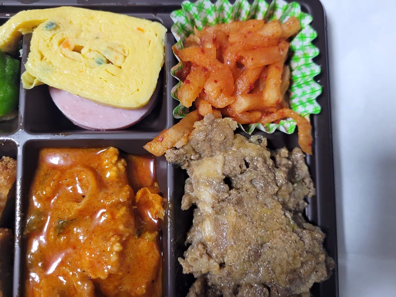 노란 계란말이 매콤한 무생채 불고기 카레 담긴 한식 도시락