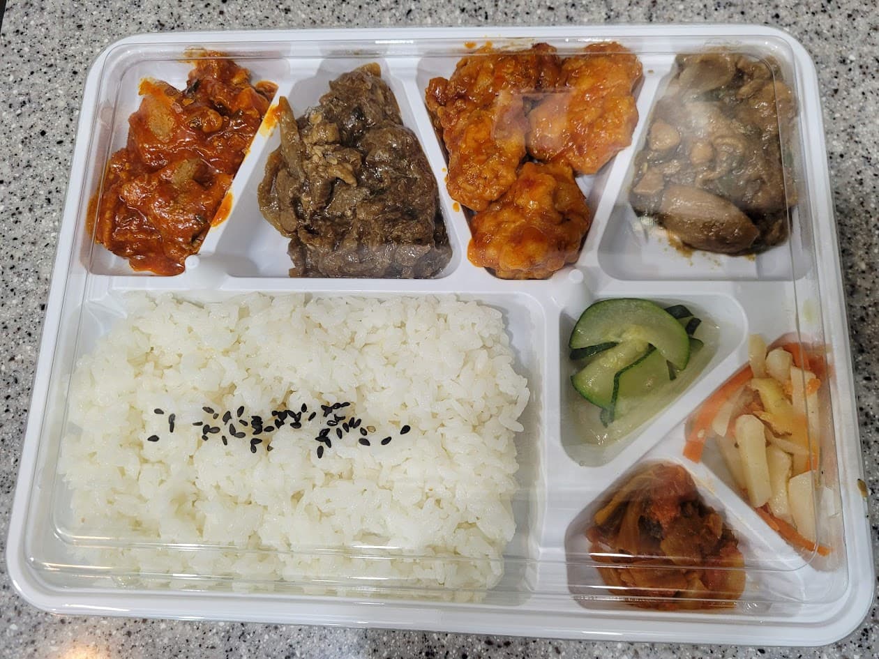 한식 도시락, 흰 밥, 볶음김치, 불고기, 양념치킨, 장조림, 오이피클, 무생채, 김치