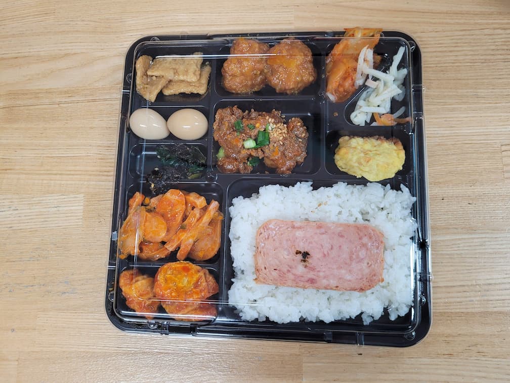 스팸, 흰밥, 치킨, 김치, 계란, 다양한 한식 반찬 도시락