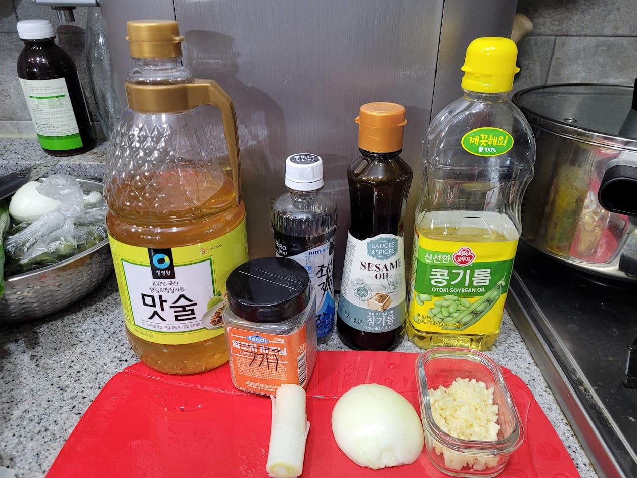 빨간 도마 위 한국 요리 참기름, 맛술, 마늘, 양파
