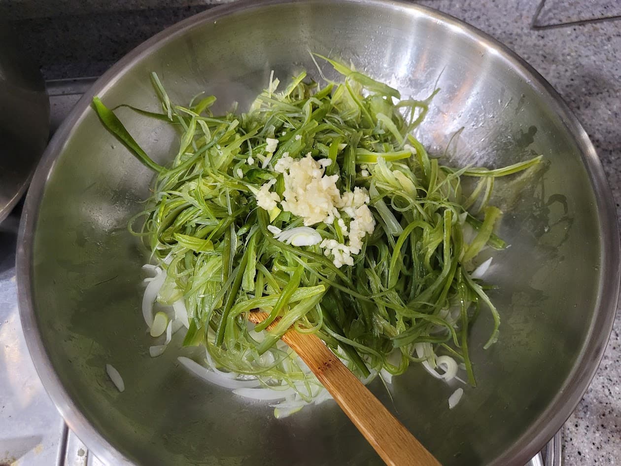 신선한 파채, 양파, 다진 마늘 스텐 볼. 나무 주걱. 요리 재료.