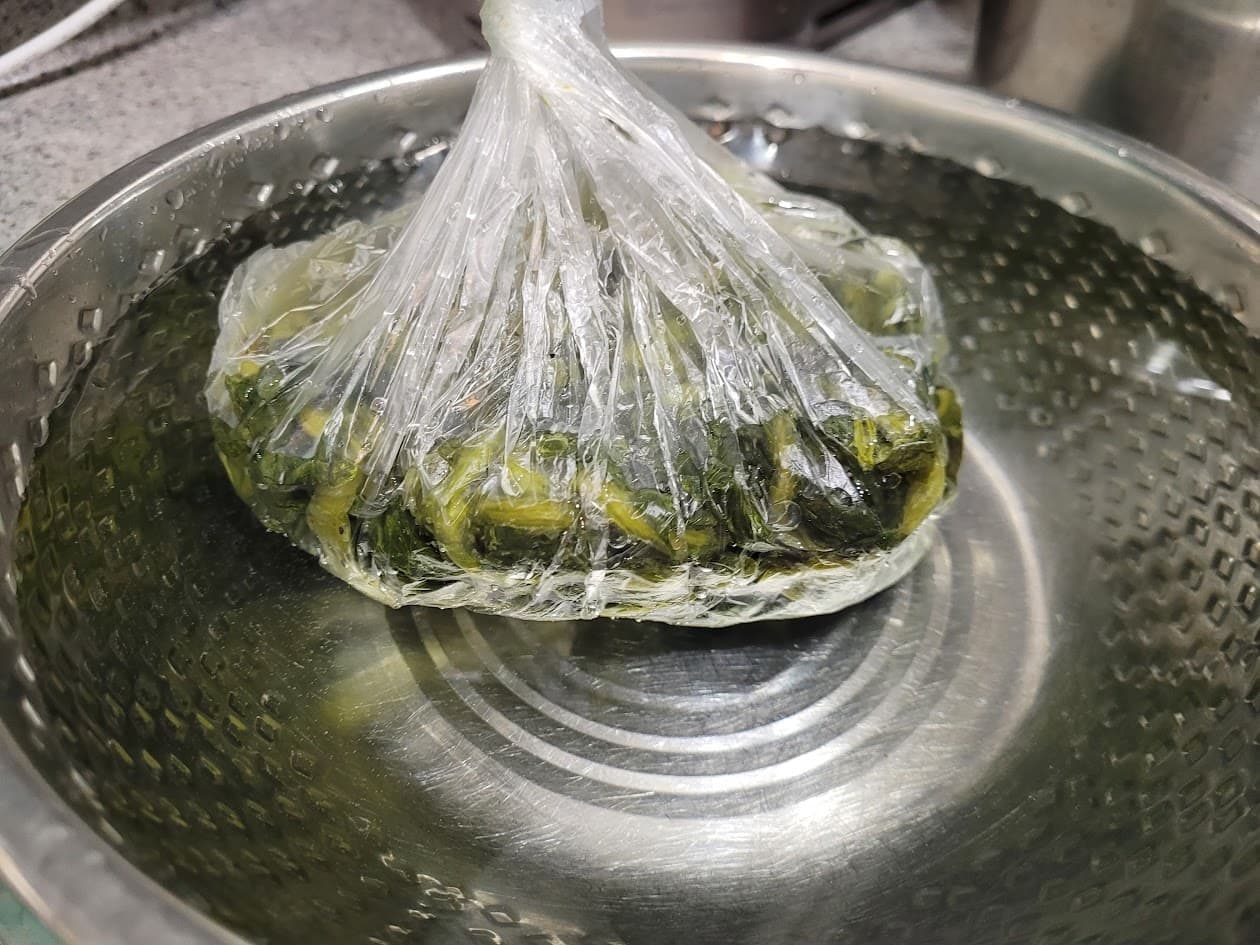 데친 녹색 잎채소 비닐봉투, 스테인리스 물그릇 잠김