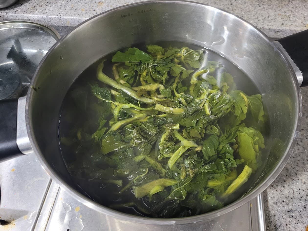 주방 냄비 속 끓는 물에 데쳐지는 푸른 잎채소