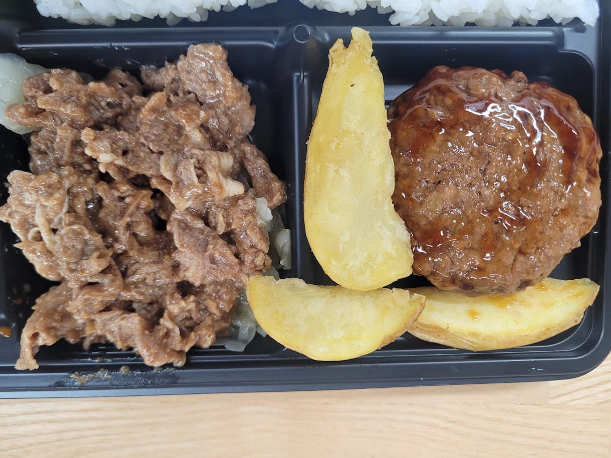 검은 도시락에 불고기, 소스 함박스테이크, 웨지감자, 밥 구성
