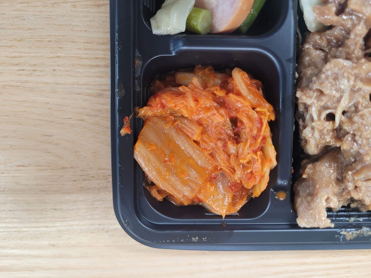 검은 도시락 칸 매콤한 배추김치, 불고기 같은 고기