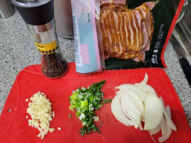 빨간 도마 위 훈제 오리고기, 다진 마늘, 대파, 양파, 후추