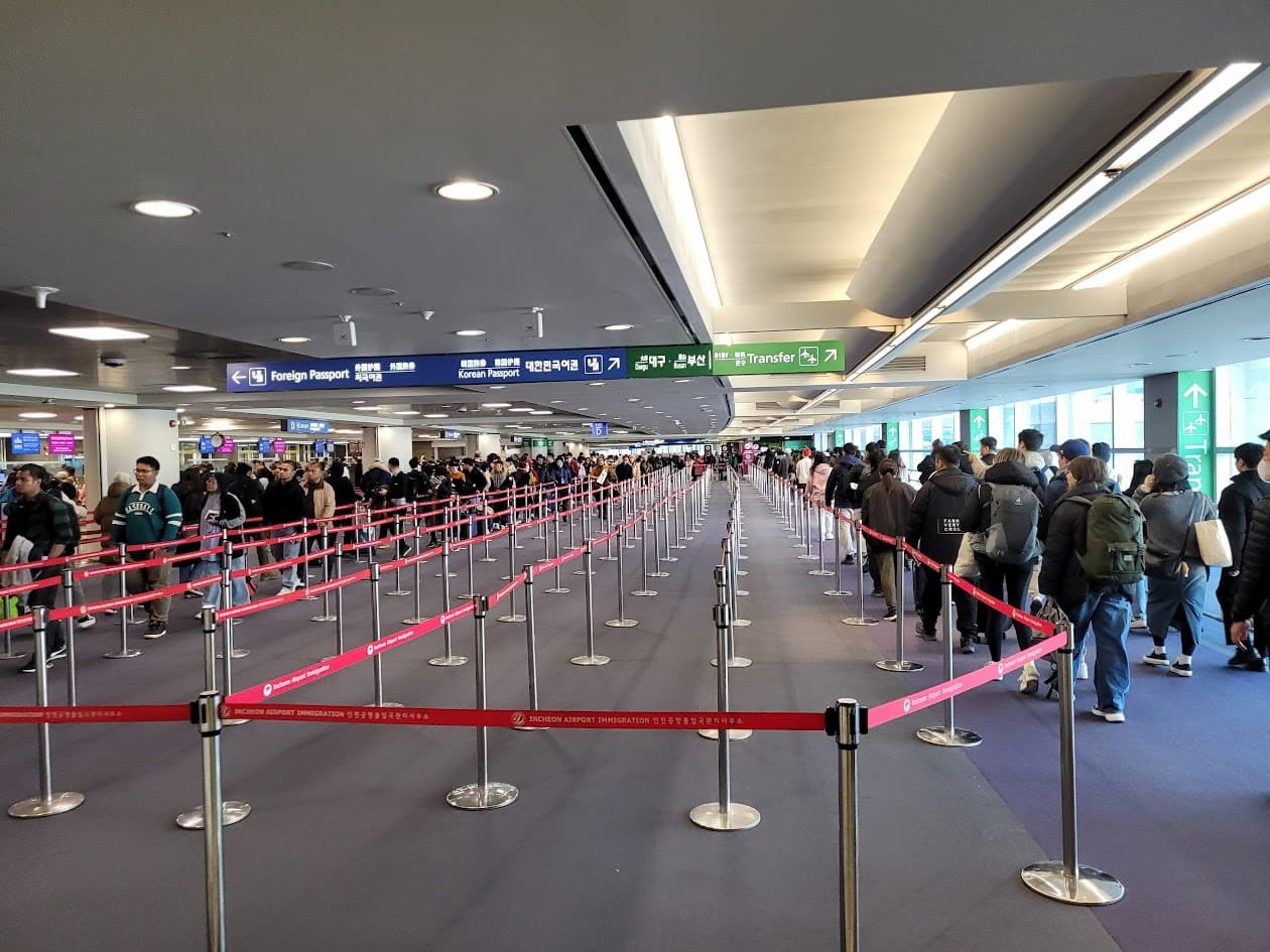 공항 입국 심사 대기열, 여행객들 안내 표지판 따라 이동