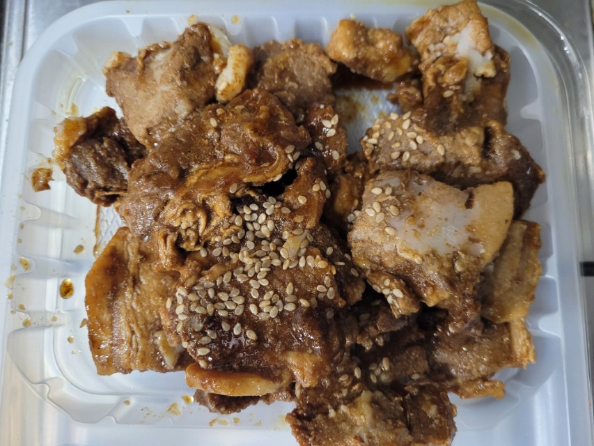깨 뿌려진 달콤 짭짤한 양념 돼지고기 요리 플라스틱 용기