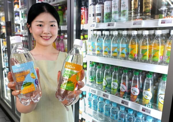 웃는 직원이 편의점서 7-SELECT 레몬 라임 탄산수 두 병 제시
