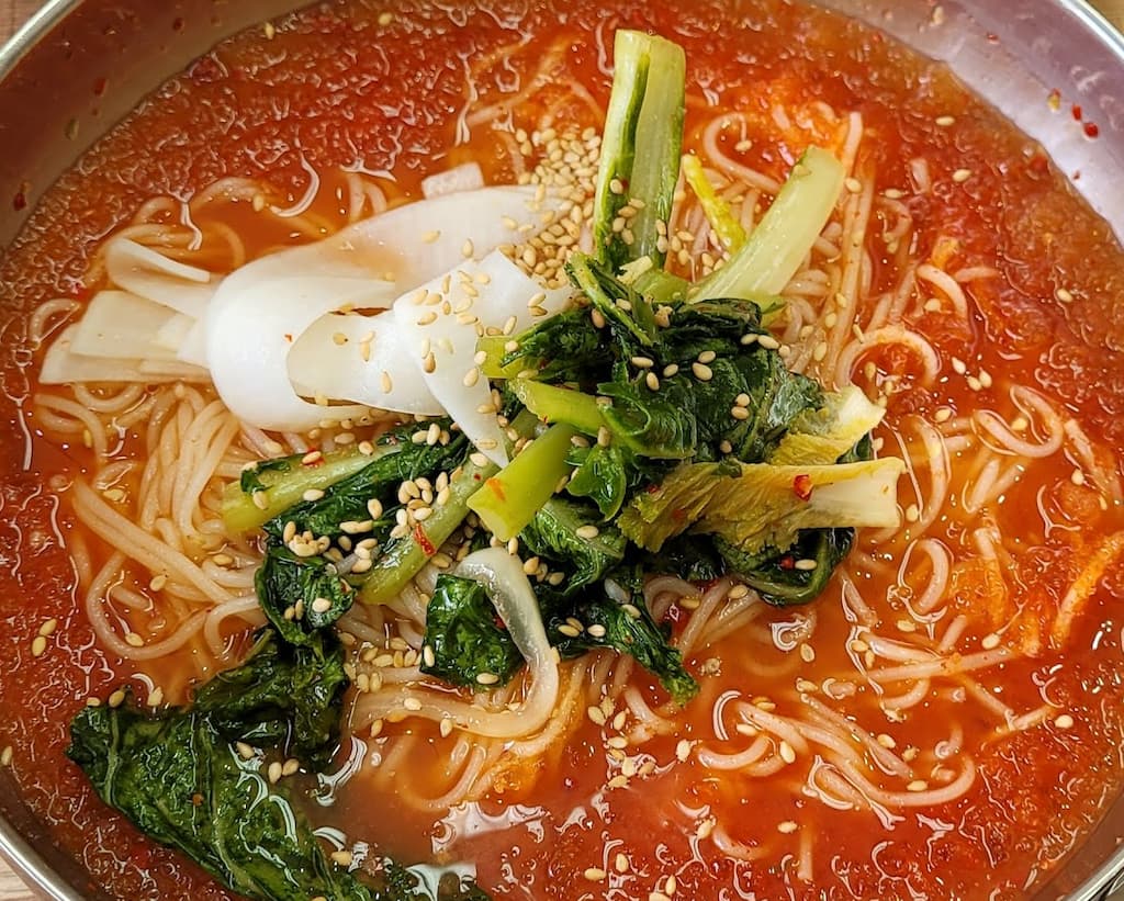 매콤한 비빔국수, 얇은 면, 무, 푸른 채소, 참깨 고명