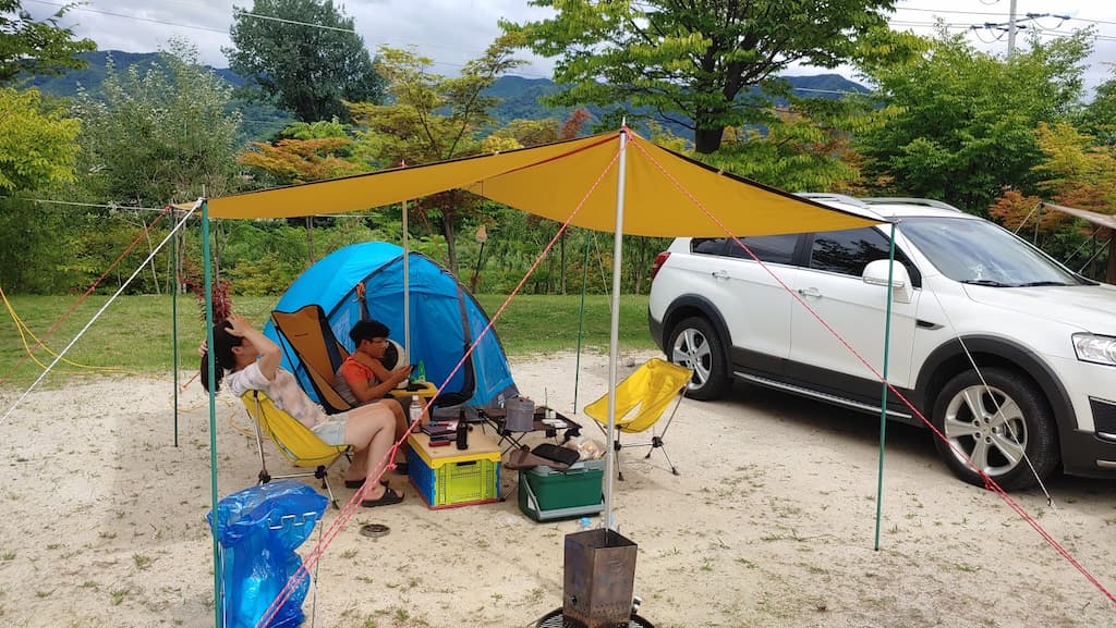 노란 타프, 파란 텐트, 하얀 SUV, 야외 캠핑 휴식