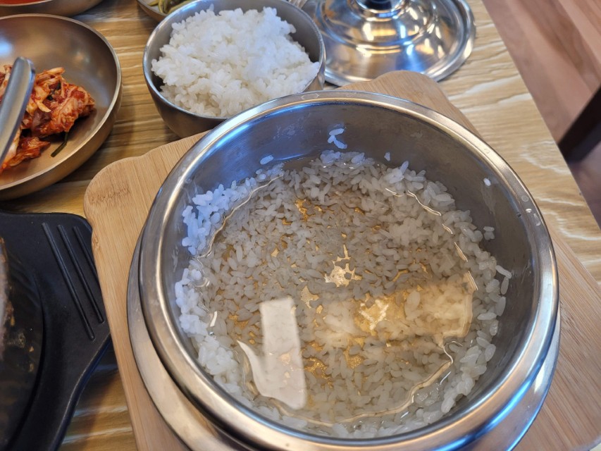 솥밥 숭늉, 따뜻한 물 부어진 누룽지. 옆 흰쌀밥, 김치.