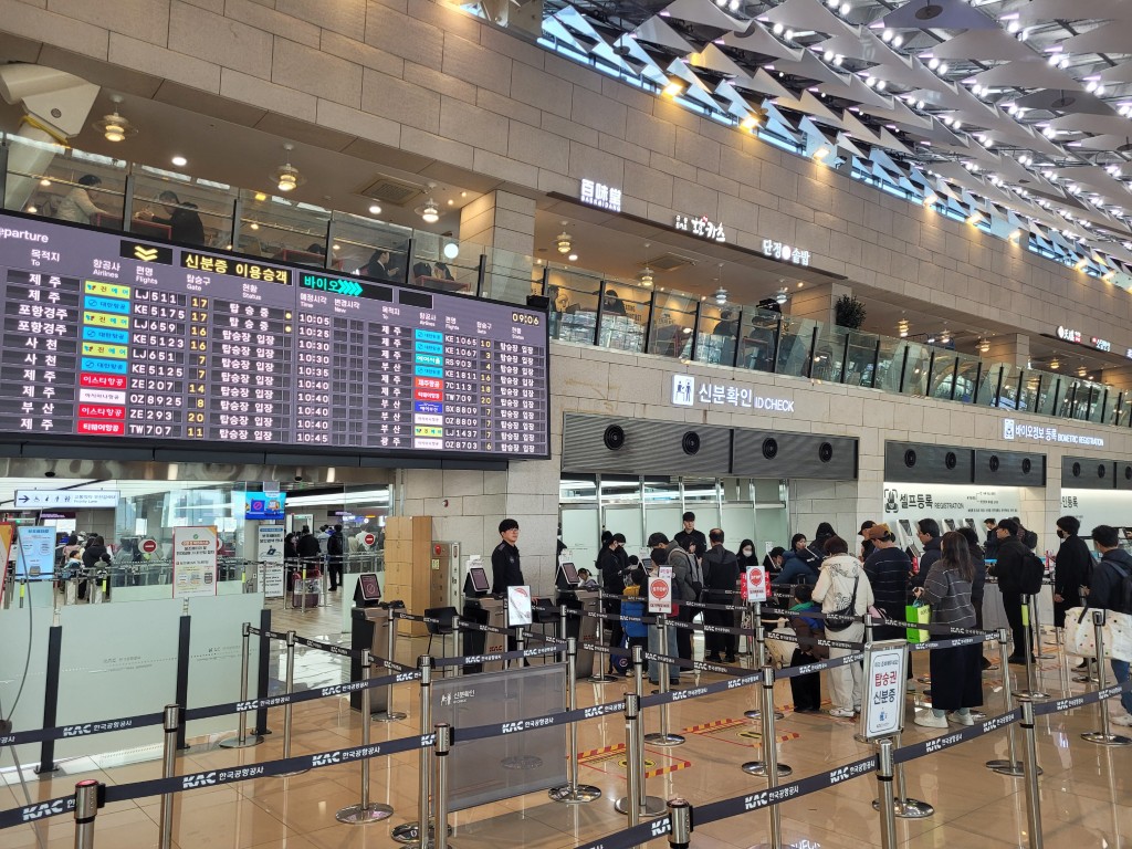 공항 출발 터미널, 대형 비행 전광판, 신분 확인 줄, 혼잡