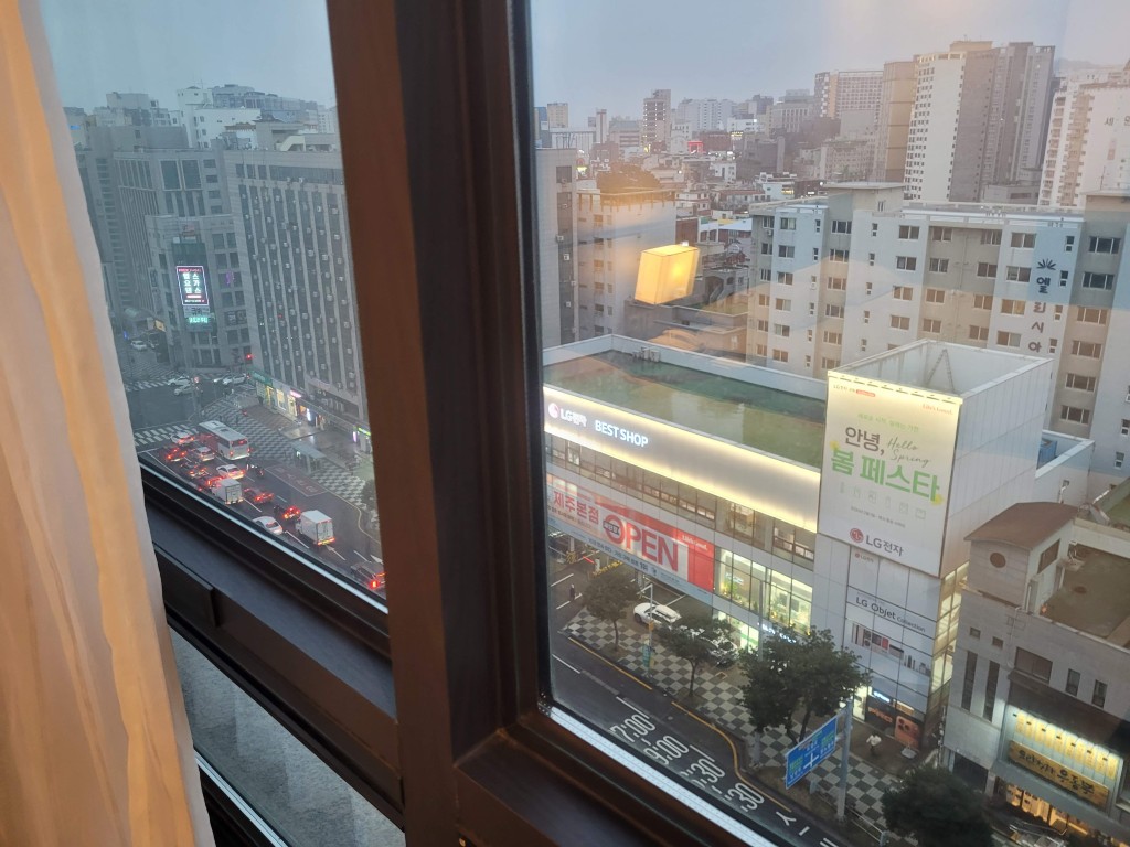 창문 너머 도심 전경, 고층 건물, 교통 체증 도로, LG 간판