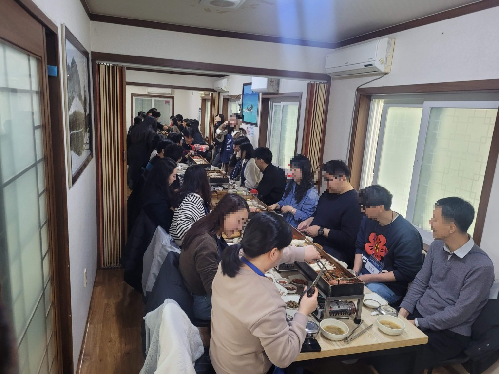 북적이는 식당 내부, 탁상 그릴로 고기 굽는 단체