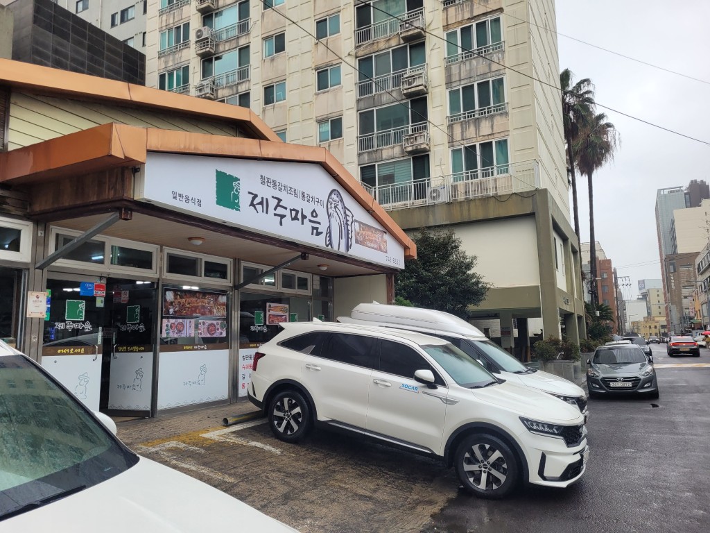 제주마음 식당, 흰색 쏘카 SUV, 도심 건물, 야자수