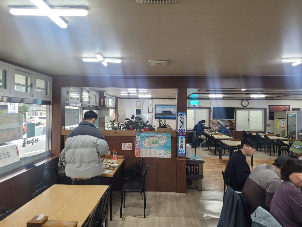 번잡한 한식당 내부, 여러 식사 테이블, 밝은 천장 조명