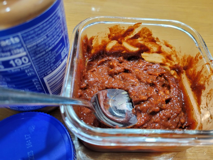 투명 용기 두꺼운 붉은 소스, 숟가락, 병, 파란 뚜껑.