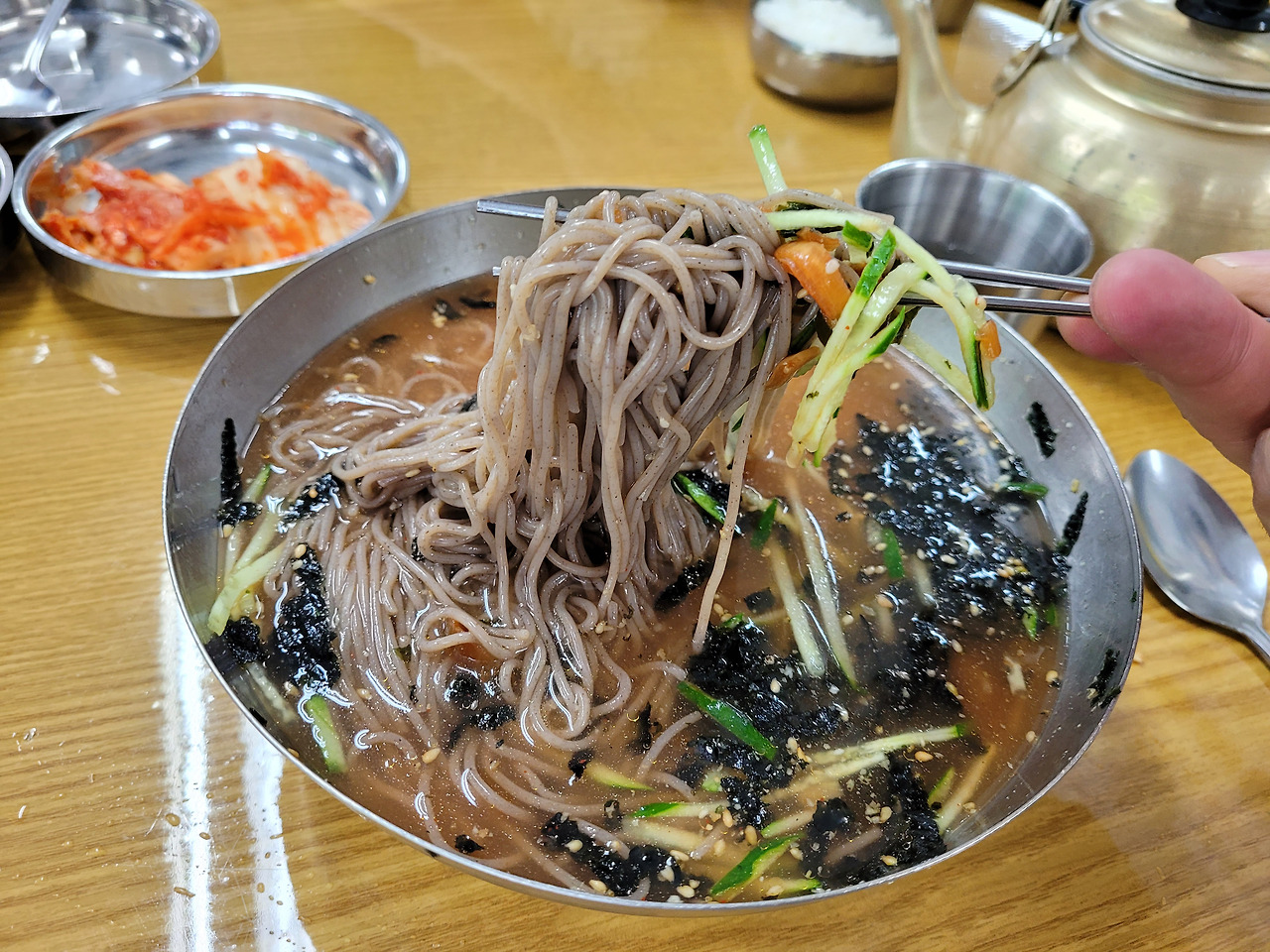 메밀 막국수 오이 김가루 고명 젓가락으로 면발 드는