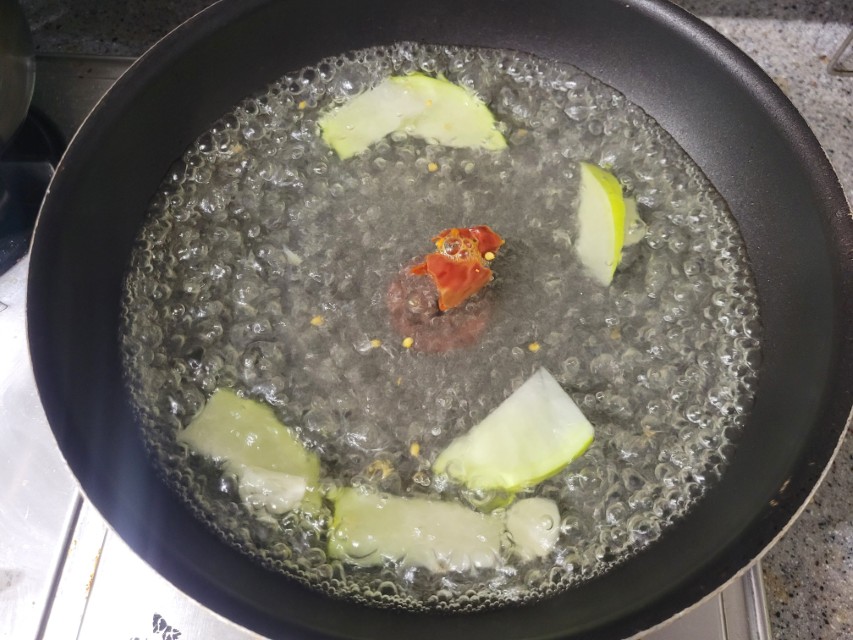 검은 팬 끓는 물, 무 조각과 빨간 고추 요리