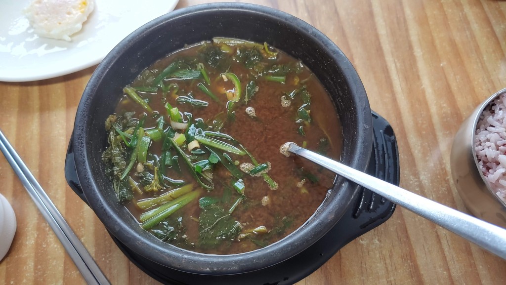뚝배기 속 푸른 채소 가득 된장찌개, 따뜻한 한식 식사