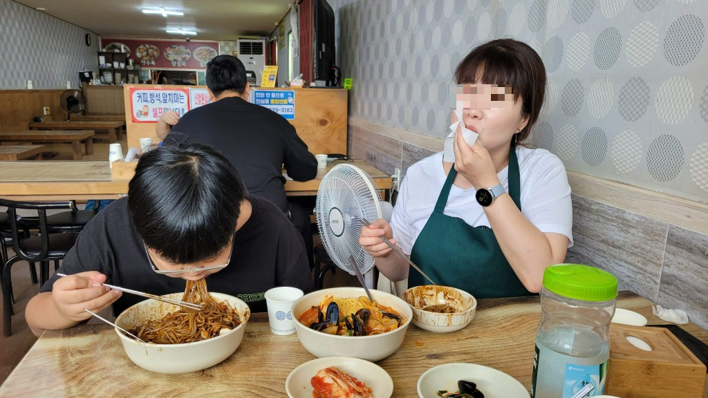 식당에서 짜장면, 짬뽕, 김치로 푸짐한 식사.