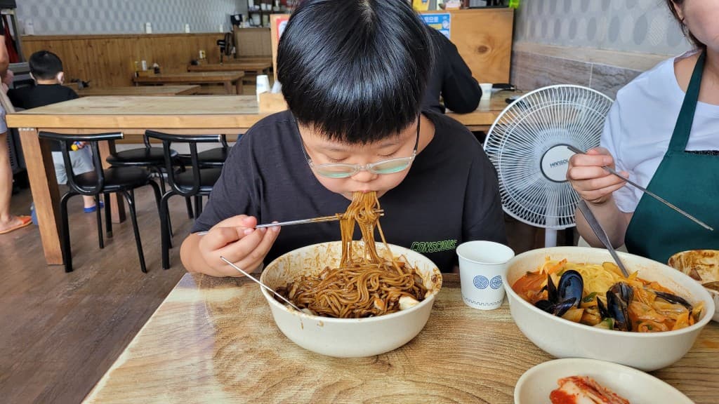 안경 쓴 아이 짜장면 젓가락으로 먹는, 식당 테이블