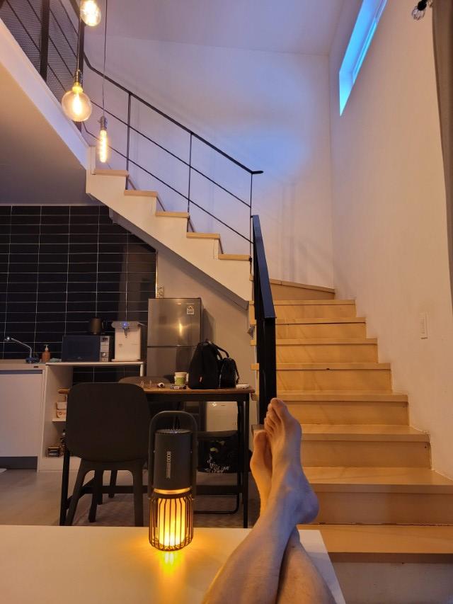 복층 거실, 나무 계단, 주방, 따뜻한 빛 랜턴, 발.