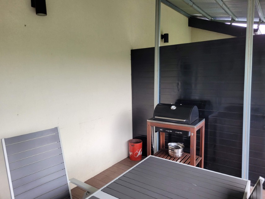 야외 테라스에 검은 그릴, 회색 테이블, 의자 배치