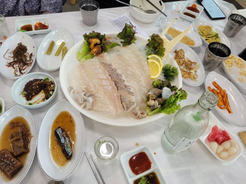 신선한 회, 해산물, 다양한 밑반찬으로 가득한 한식 식탁.