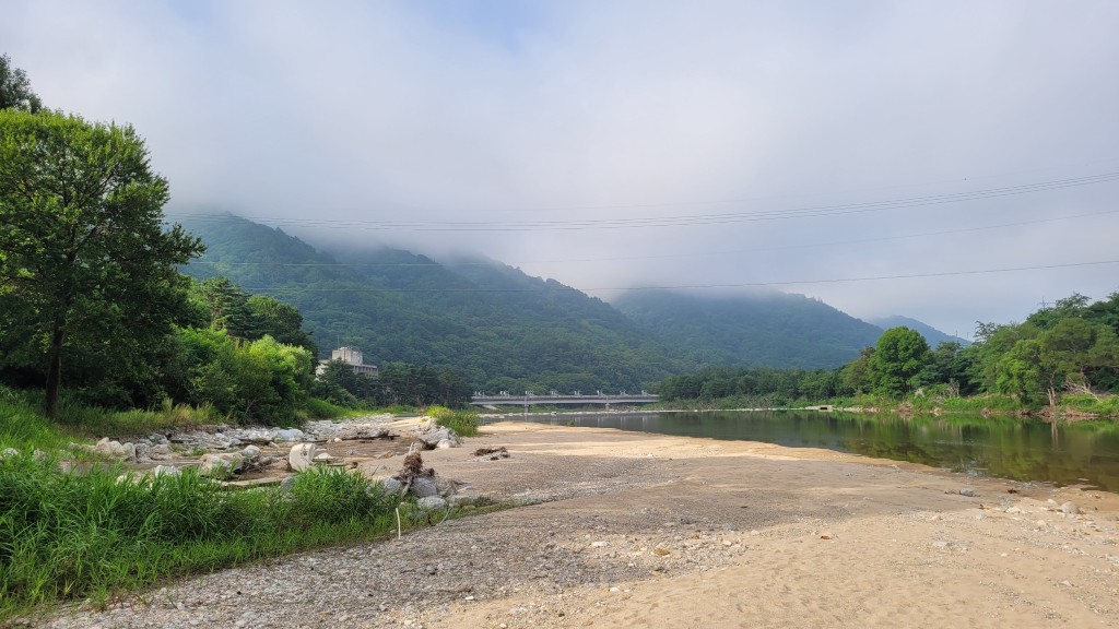 모래 강변, 푸른 산, 흐린 하늘, 멀리 다리