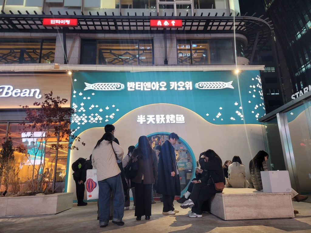밤거리 밝은 생선구이 식당 앞 대기하는 무리