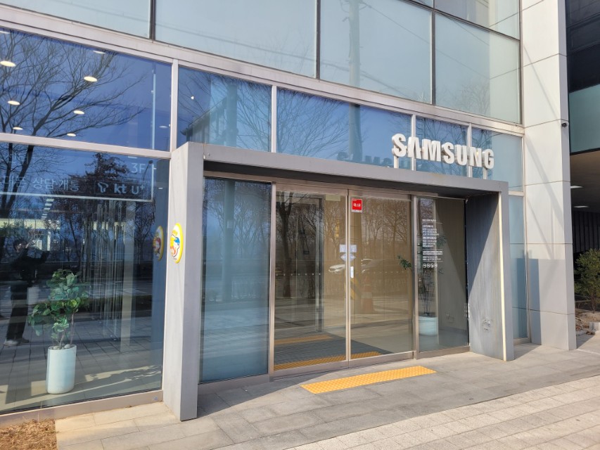 삼성 건물 유리 외벽, 자동문, SAMSUNG 로고, 노란 점자 블록.