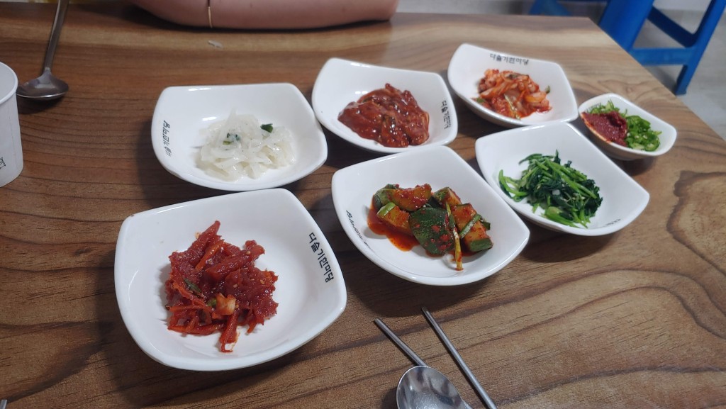 나무 테이블 위 정갈하게 놓인 여러 가지 한식 반찬