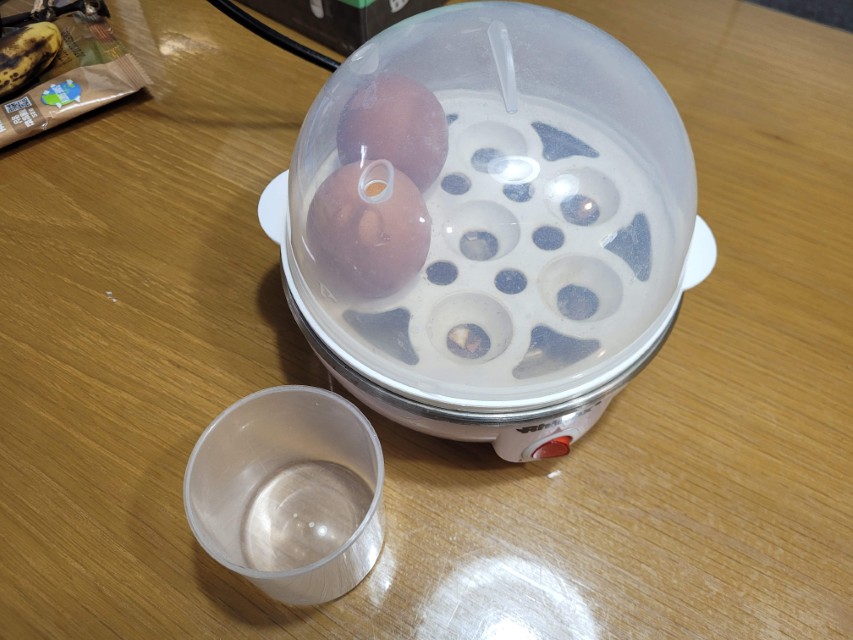 투명 뚜껑 에그 쿠커, 두 달걀, 옆 계량컵, 나무 탁자